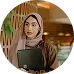 A confident woman wearing a hijab and holding a laptop in a modern setting, highlighting the diverse and inclusive player base of KuyaPlay.