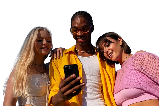 Three friends happily gathered around a mobile phone, smiling as they view something on the screen, symbolizing social enjoyment and engagement with KuyaPlay login.